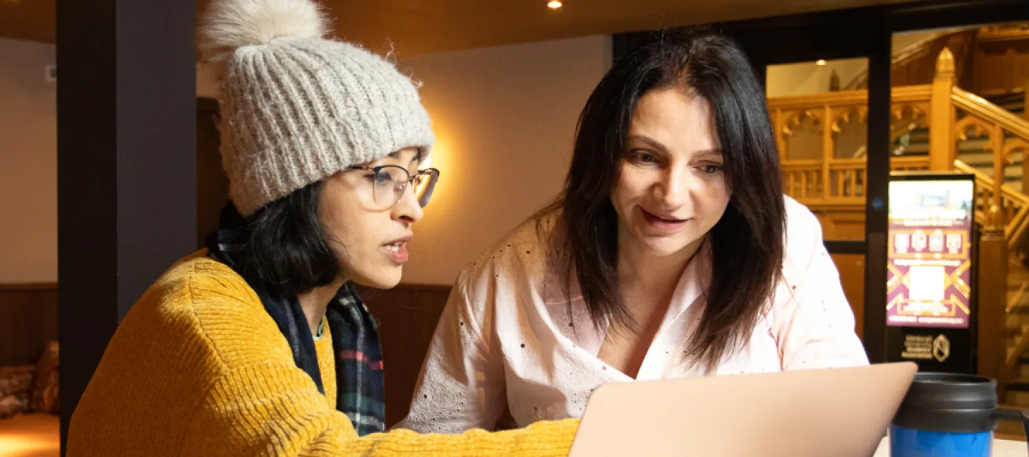 EBB Scholar looking at a laptop alongside their mentor