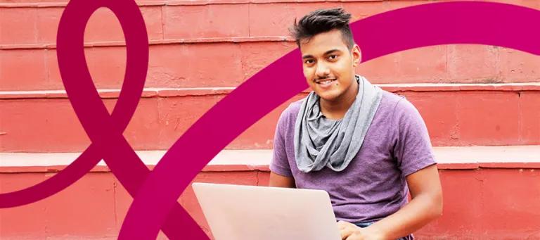 Male scholar working on laptop with EBB branding in the background